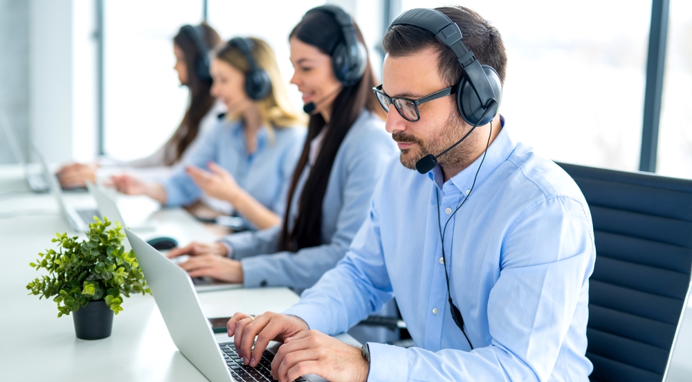 Call centre operators using headphones and laptops